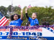 two little girls on the back of a parade trailer